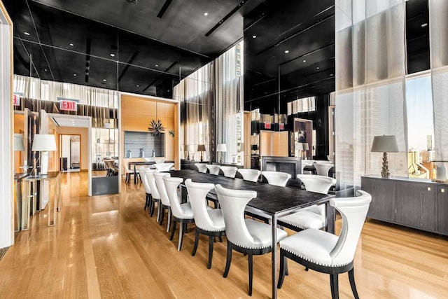 dining area featuring wood finished floors and a towering ceiling