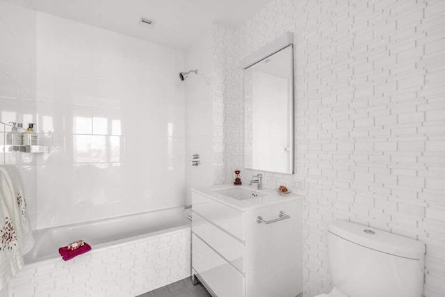 bathroom with toilet, vanity, and  shower combination