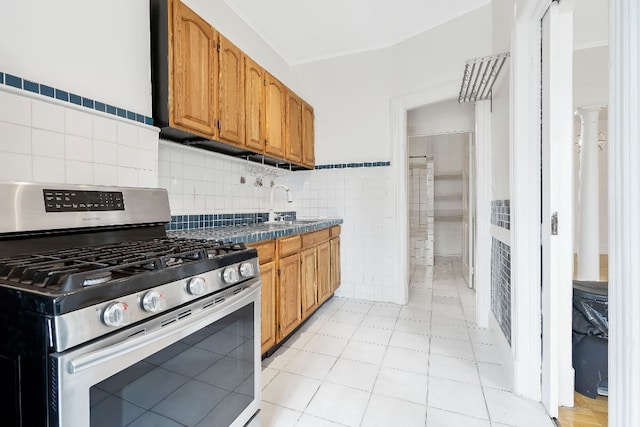 64-07 68th Ave, New York City, NY 11385 - kitchen featuring stainless steel gas range, tile counters, a sink, brown cabinets, and tile walls