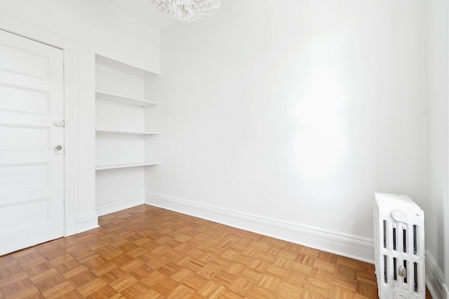 64-07 68th Ave, New York City, NY 11385 - unfurnished room with radiator heating unit, baseboards, and a chandelier