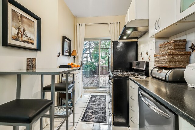 64-07 68th Ave, New York City, NY 11385 - kitchen featuring stainless steel appliances, decorative backsplash, white cabinets, and dark countertops