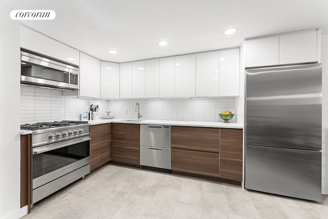 322 W 22nd St Unit 2, New York City, NY 10011 - kitchen with appliances with stainless steel finishes, modern cabinets, a sink, white cabinets, and recessed lighting