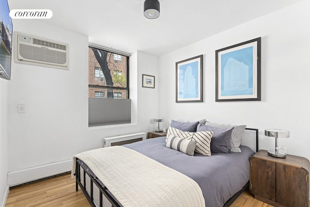 322 W 22nd St Unit 2, New York City, NY 10011 - bedroom featuring a baseboard radiator, light wood-type flooring, and a wall mounted air conditioner