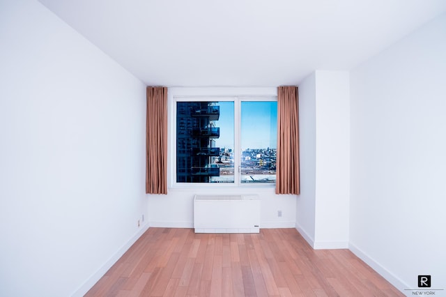 22 N 6th St Unit 20-D, New York City, NY 11249 - unfurnished room featuring radiator heating unit, wood finished floors, and baseboards