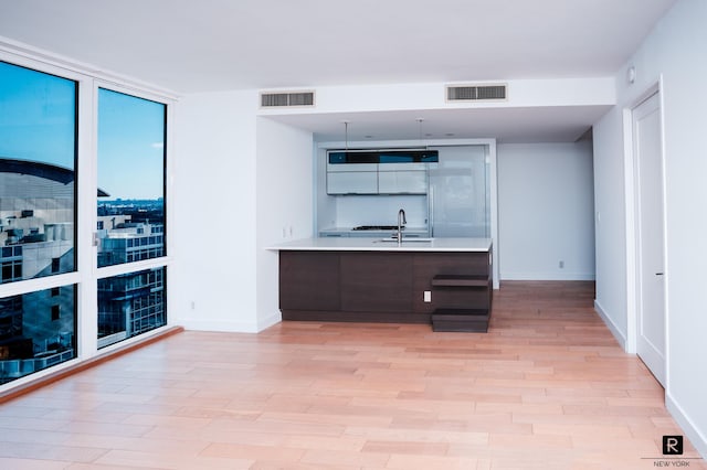 22 N 6th St Unit 20-D, New York City, NY 11249 - kitchen featuring a sink, light wood-style floors, a peninsula, light countertops, and baseboards