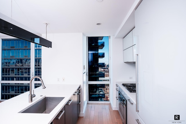 22 N 6th St Unit 20-D, New York City, NY 11249 - kitchen with a sink, modern cabinets, light wood finished floors, white cabinetry, and light countertops