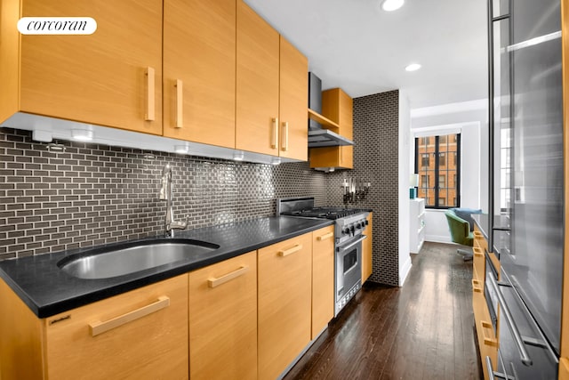 201 W 16th St Unit 12Dg, New York City, NY 10011 - kitchen with high end appliances, wall chimney range hood, dark wood finished floors, tasteful backsplash, and recessed lighting