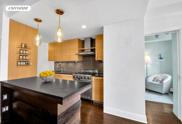 201 W 16th St Unit 12Dg, New York City, NY 10011 - kitchen featuring high end stove, dark countertops, wall chimney exhaust hood, dark wood-type flooring, and backsplash