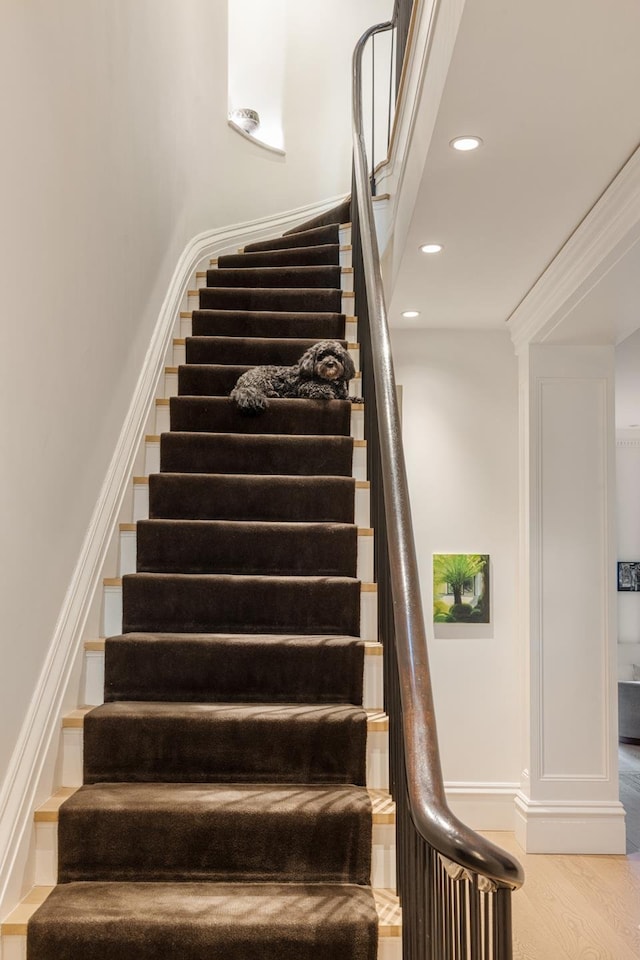 staircase with recessed lighting, wood finished floors, and baseboards