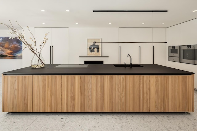 kitchen featuring dark countertops, a sink, oven, modern cabinets, and white cabinetry