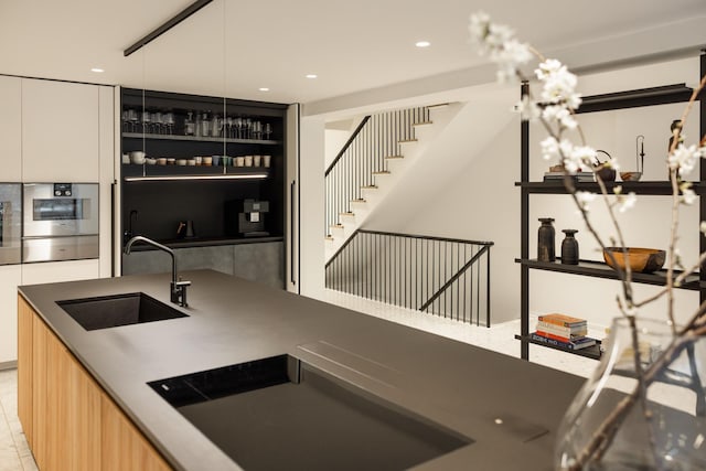 kitchen featuring a sink, modern cabinets, stainless steel oven, a warming drawer, and recessed lighting