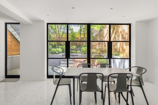 dining room featuring baseboards and floor to ceiling windows