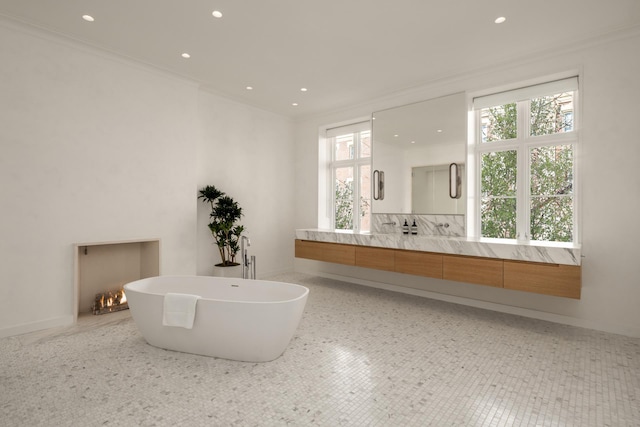 full bathroom with a freestanding tub, recessed lighting, vanity, and crown molding