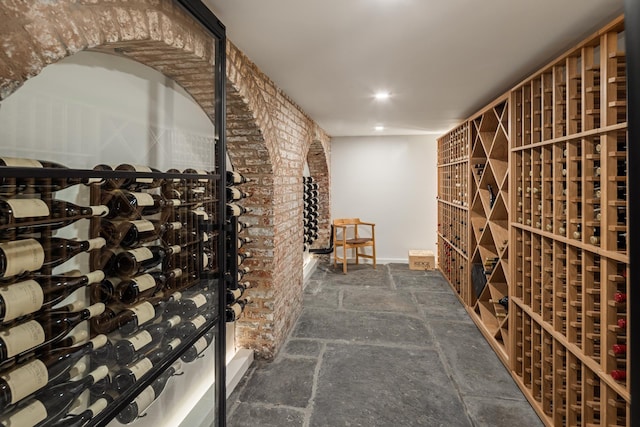 wine room with stone tile flooring and brick wall