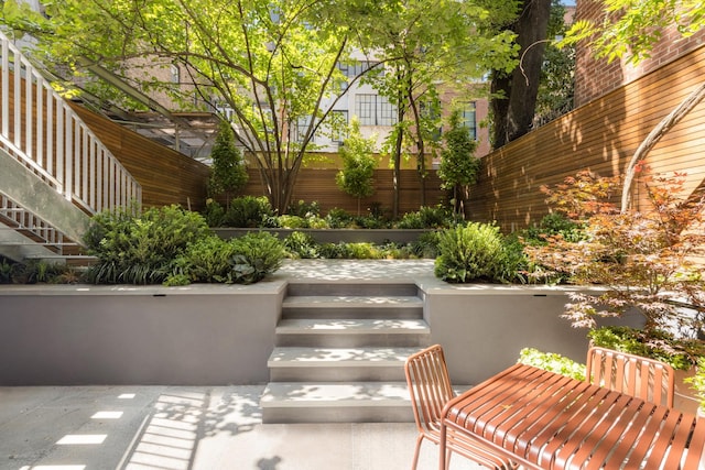 view of patio / terrace featuring stairway and fence