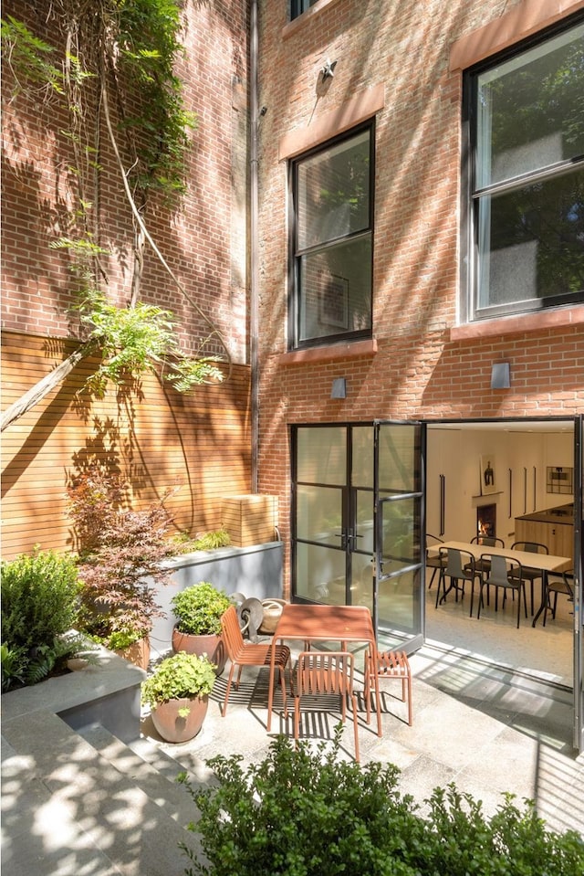 back of house featuring a patio area, french doors, and brick siding