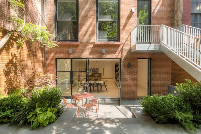 back of house with brick siding and a patio