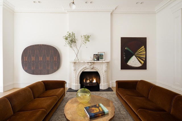 living room featuring a high end fireplace and crown molding