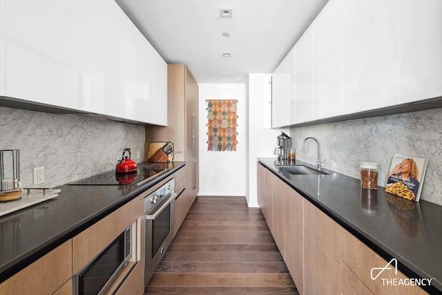 302 E 96th St Unit 1403, New York City, NY 10128 - kitchen featuring modern cabinets, a sink, appliances with stainless steel finishes, and dark countertops