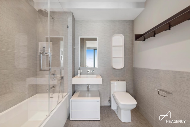 302 E 96th St Unit 1403, New York City, NY 10128 - full bath with tile walls, toilet, bath / shower combo with glass door, and vanity
