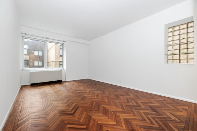 unfurnished room featuring baseboards and radiator