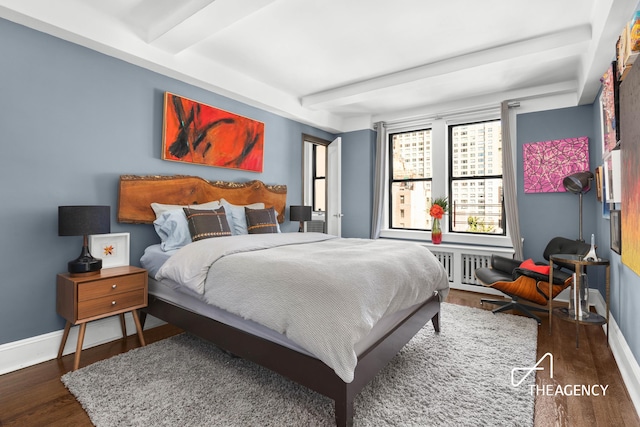 333 E 53rd St Unit 10C, New York City, NY 10022 - bedroom featuring beam ceiling, wood finished floors, and baseboards