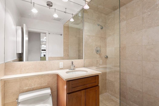 59 E 73rd St, New York City, NY 10021 - bathroom featuring toilet, a walk in shower, vanity, and tile walls