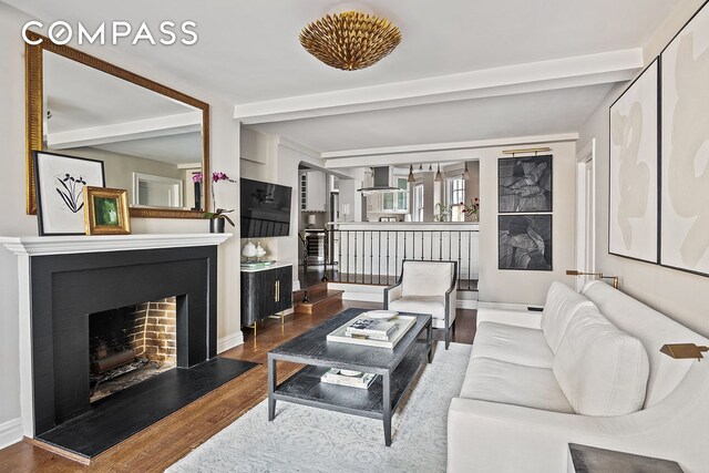 302 W 12th St Unit 5G, New York City, NY 10014 - living room with wood finished floors, a fireplace with raised hearth, baseboards, and beam ceiling