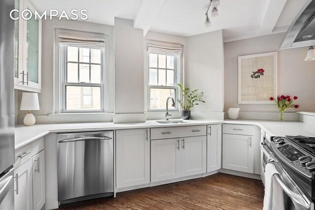 302 W 12th St Unit 5G, New York City, NY 10014 - kitchen with wall chimney range hood, light countertops, a sink, stainless steel appliances, and dark wood-type flooring