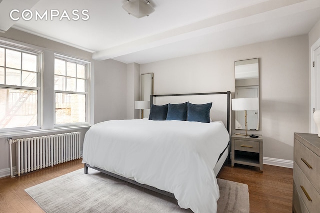 302 W 12th St Unit 5G, New York City, NY 10014 - bedroom with radiator heating unit, baseboards, and wood finished floors