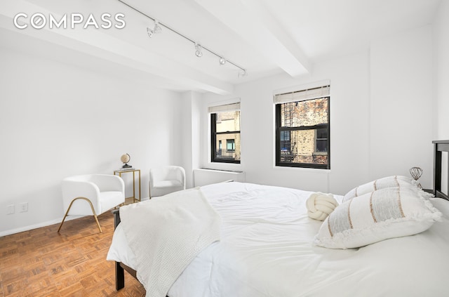 bedroom featuring track lighting and baseboards