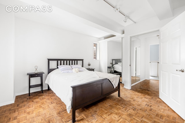 bedroom with baseboards and rail lighting