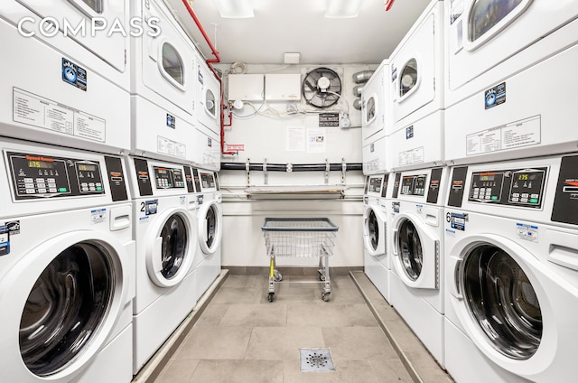 communal laundry room with estacked washer and dryer, washer and clothes dryer, and light tile patterned flooring