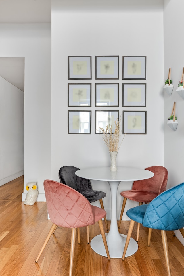 dining area with wood finished floors, breakfast area, and baseboards
