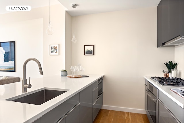 236 17th St Unit 6C, New York City, NY 11215 - kitchen featuring stainless steel appliances, gray cabinetry, a sink, light wood-type flooring, and baseboards