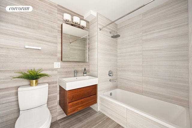 236 17th St Unit 6C, New York City, NY 11215 - full bathroom featuring toilet, tiled shower / bath, vanity, and tile walls