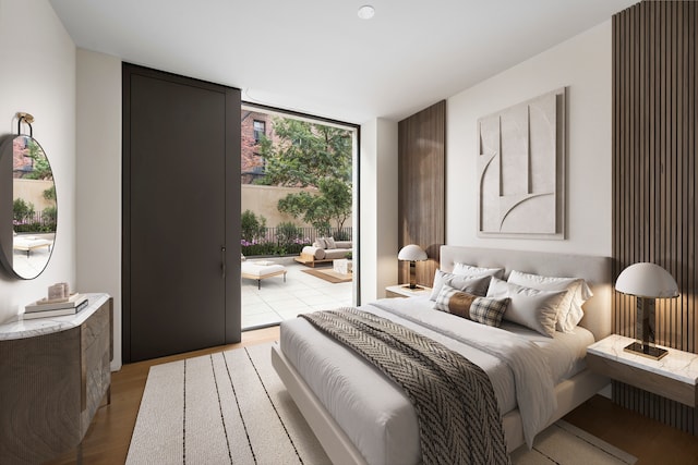 bedroom with expansive windows, light wood finished floors, and access to exterior