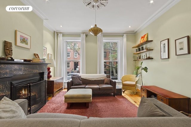 sitting room featuring crown molding, recessed lighting, wood finished floors, and a warm lit fireplace
