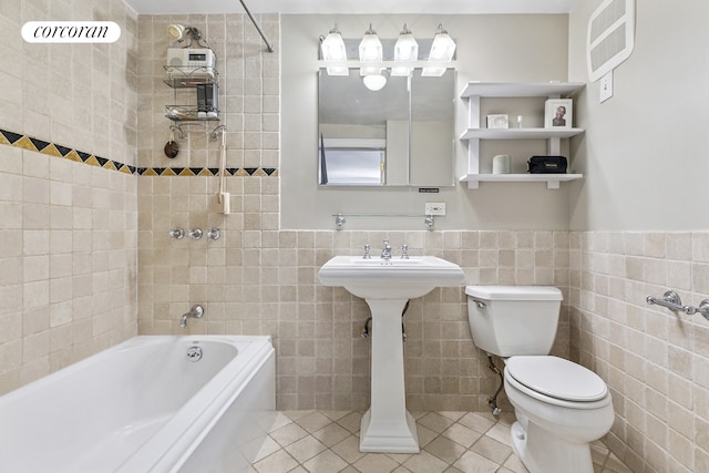 bathroom featuring toilet, tile walls, tile patterned flooring, and bathtub / shower combination