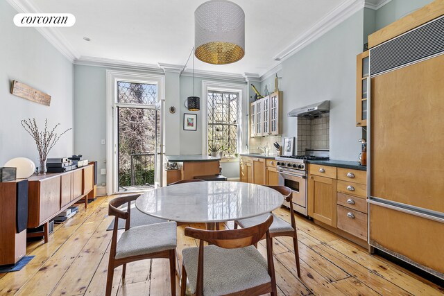dining room featuring light wood-style floors, crown molding, and visible vents