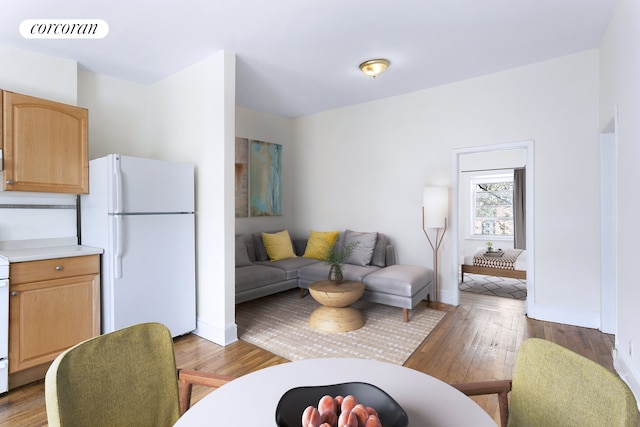 living area featuring baseboards, visible vents, and wood finished floors