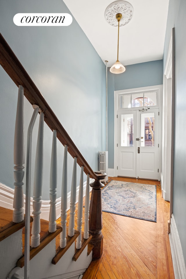 entrance foyer featuring light wood-style flooring, baseboards, and stairs