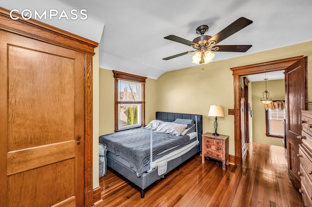 bedroom with baseboards, ceiling fan, vaulted ceiling, and hardwood / wood-style flooring