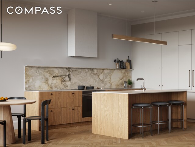 kitchen with a kitchen bar, crown molding, modern cabinets, tasteful backsplash, and white cabinets
