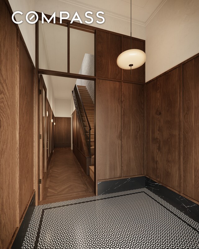 staircase featuring wooden walls
