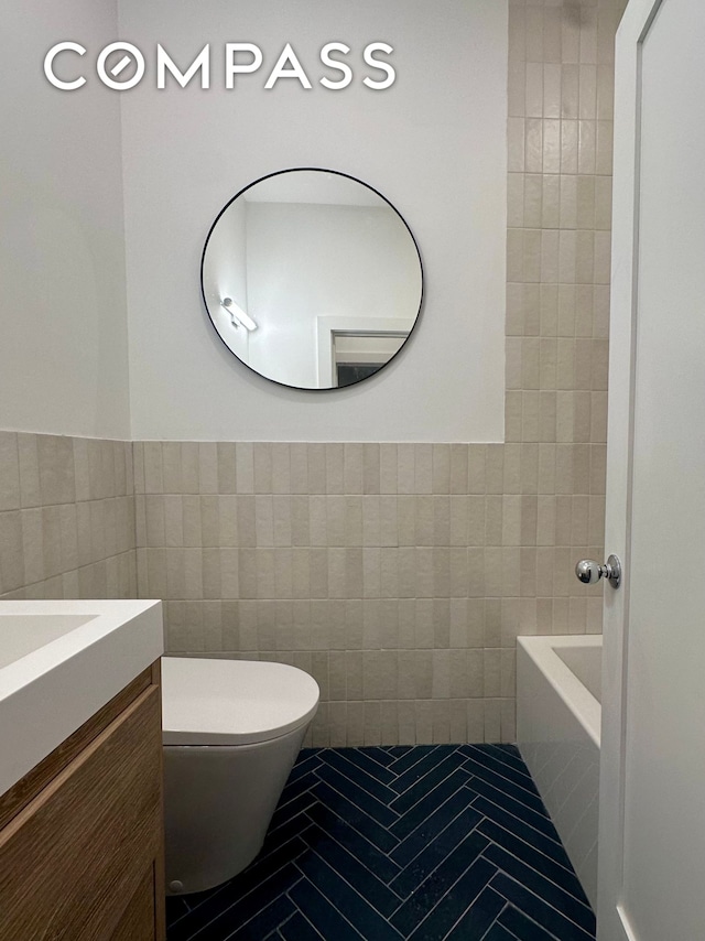 129 Malcolm X Blvd Unit 1, New York City, NY 11221 - bathroom with tile walls, vanity, toilet, tile patterned flooring, and wainscoting