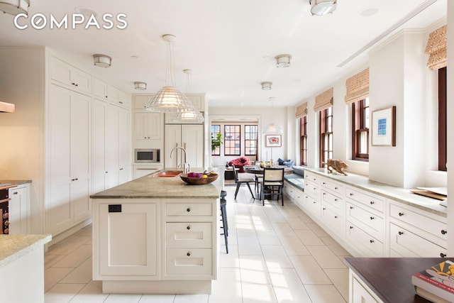 823 Park Ave Ph, Ph, New York City, NY 10021 - kitchen with built in appliances, a sink, light tile patterned floors, pendant lighting, and a kitchen island with sink