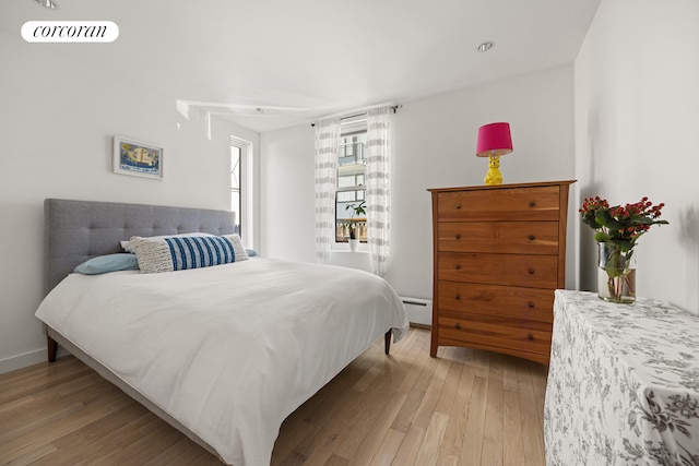 67 Dean St, New York City, NY 11201 - bedroom featuring a baseboard heating unit, light wood-style floors, and baseboards