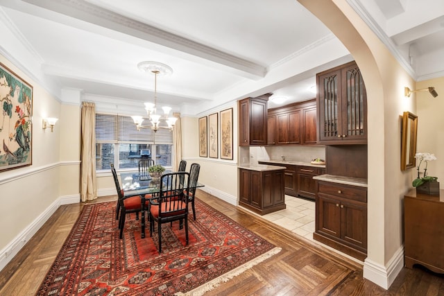 670 W End Ave Unit 5A, New York City, NY 10025 - dining room featuring a chandelier, beamed ceiling, baseboards, arched walkways, and crown molding