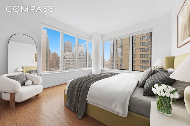 bedroom featuring a skyline view and wood finished floors